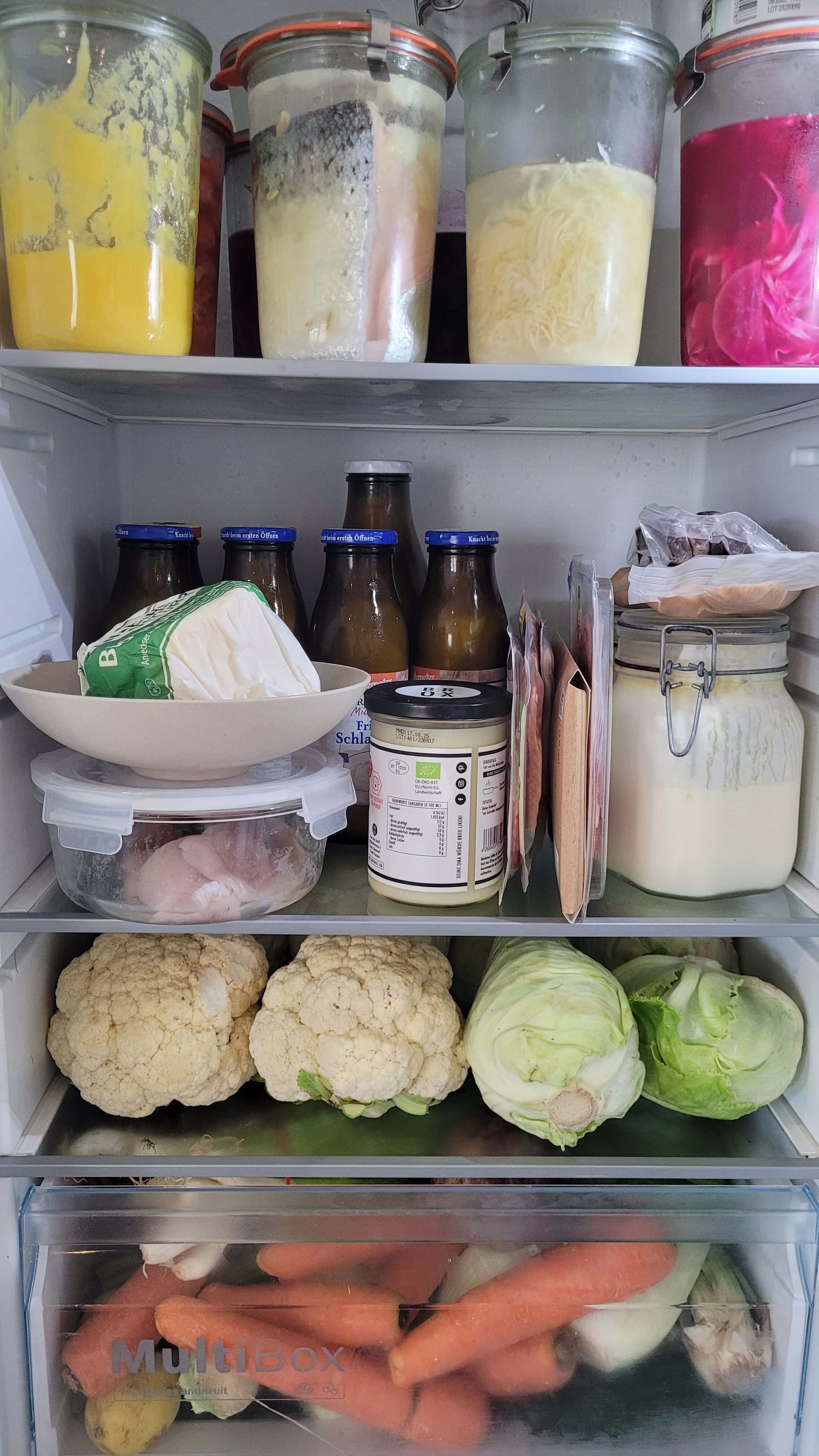 Kühlschrank mit Gemüse und traditionellen Lebensmitteln wie Ghee, fermentiertem Fisch, Butter und Fleisch