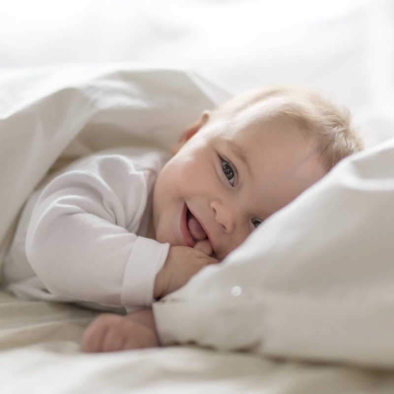 A Cute happy 7 month baby girl in diaper lying and playing